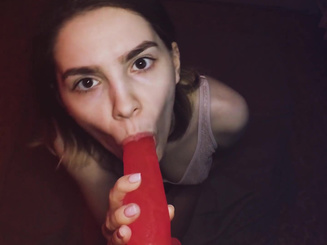 Молоденькая шлюха с пустыми глазами отсасывает красный фаллоимитатор для удовольствия